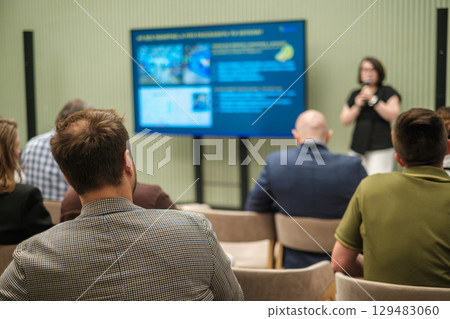 Business professionals attending a lecture with presentation on a large screen Business professionals attending a lecture with presentation on a large screen 129483060