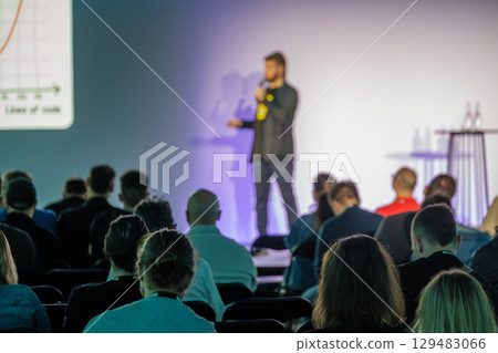 Speaker presenting to audience at educational seminar with a visual presentation 129483066