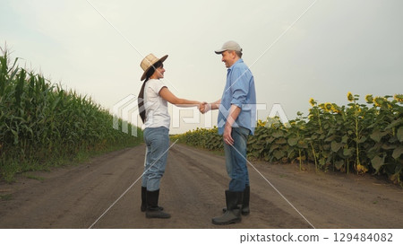 two farmers man woman shake hands conclude deal, business partners field corn sunflowers, smiling welcoming, Agriculture, teamwork, business partner farmer agriculture, handshake sign of deal, harvest two farmers man woman shake hands conclude deal, business partners field corn sunflowers, smiling welcoming, Agriculture, teamwork, business partner farmer agriculture, handshake sign of deal, harvest 129484082