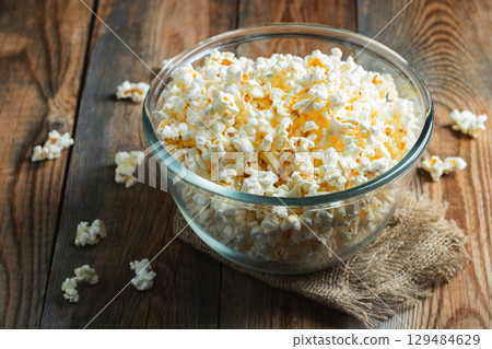 Pop corn on wood color background.Food and snack concepts ideas.Minimal style top view mockup Pop corn on wood color background.Food and snack concepts ideas.Minimal style top view mockup 129484629