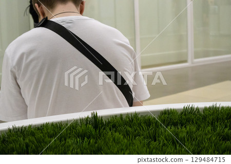 Rear view of a young man in a white T-shirt, leaning his head forward 129484715