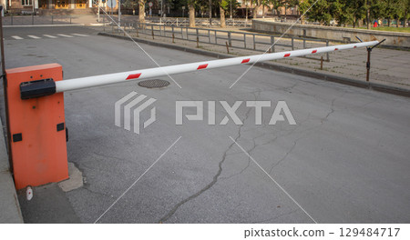 Red and white metal barrier, blocking the road, protecting the territory, controlling entry Red and white metal barrier, blocking the road, protecting the territory, controlling entry 129484717