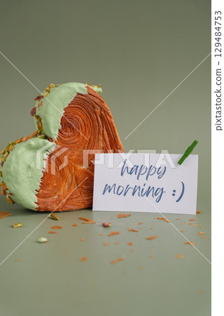 HAPPY MORNING holiday text paper note Delightful and vibrant heartshaped pastry croissant treat, beautifully topped with colorful frosting nut galore. Mock up template copy space. Food experimentation HAPPY MORNING holiday text paper note Delightful and vibrant heartshaped pastry croissant treat, beautifully topped with colorful frosting nut galore. Mock up template copy space. Food experimentation 129484753