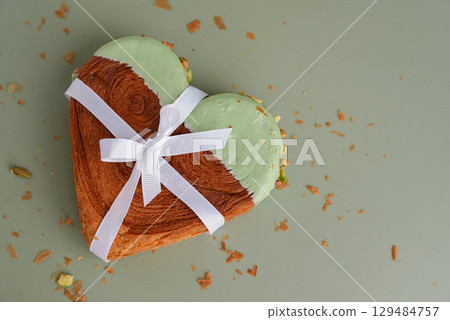 Present gift ribbon holiday Valentine's Birthday love symbol Delightful and vibrant heartshaped pastry croissant treat, beautifully topped with colorful frosting nut galore. Mock up template copy 129484757