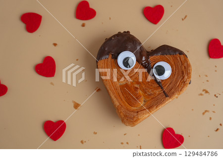 April fool day funny creative eyes on Delicious fresh croissant topped with Dark chocolate flavor Ganache. Creation unique heart shape bakery. Puff pastry holiday love gift present idea Valentine's 129484786