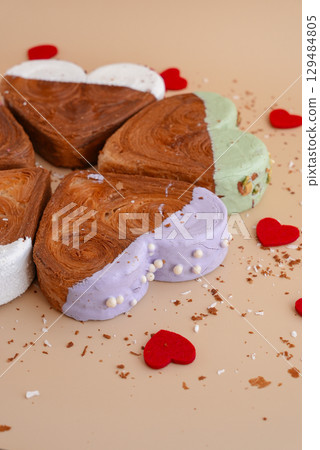 Flat lay greeting card Valentine's Day Delicious fresh variety croissants topped with colorful flavor Ganache. Creation unique heart shape bakery. Puff pastry holiday love gift present idea Flat lay greeting card Valentine's Day Delicious fresh variety croissants topped with colorful flavor Ganache. Creation unique heart shape bakery. Puff pastry holiday love gift present idea 129484805