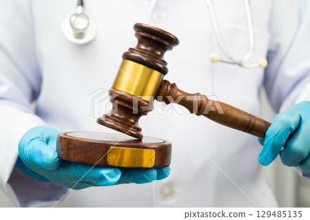 Doctor holding judge gavel, forensic medicine, medical law and crime justice. 129485135