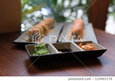 Chopsticks Japan Sushi In Japanese Restaurant.Traditional Sushi Maki Rolls Sushi Salmon Philadelphia Cheese Avocado, Cucumber, Rice And Nori. Japanese Food Sushi Roll Uramaki, Nigiri And Hosomaki 129485176