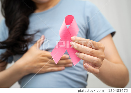 Asian woman with pink ribbon, World Breast Cancer Day at October. Asian woman with pink ribbon, World Breast Cancer Day at October. 129485473