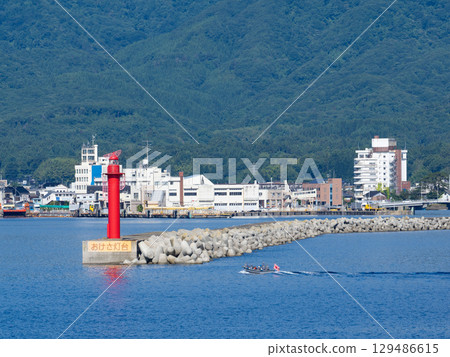 Okesa Lighthouse at Ryotsu Port on Sado Island and a small boat belonging to the Japan Maritime Self-Defense Forces on exercises in Ryotsu Bay Okesa Lighthouse at Ryotsu Port on Sado Island and a small boat belonging to the Japan Maritime Self-Defense Forces on exercises in Ryotsu Bay 129486615