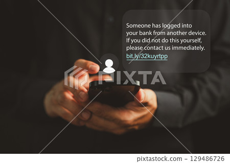 Person receiving a phishing scam message on a smartphone, warning about suspicious bank login. Concept of cyber fraud, identity theft, and digital financial deception via SMS or malicious links. 129486726