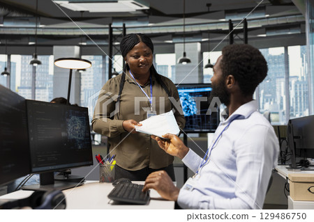 Bookkeeper in office reviewing financial records using AI assistant for support. Accountant using large language model chatbot to automate routine calculations and reporting tasks Bookkeeper in office reviewing financial records using AI assistant for support. Accountant using large language model chatbot to automate routine calculations and reporting tasks 129486750