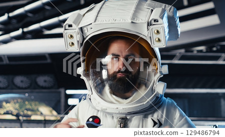 Portrait of joyful astronaut holding helmet doing scheduled operations in starship exploring deep space. Upbeat cosmonaut inspecting spacecraft hull after leaving planet Portrait of joyful astronaut holding helmet doing scheduled operations in starship exploring deep space. Upbeat cosmonaut inspecting spacecraft hull after leaving planet 129486794