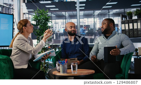 Team of multicultural associates engaging in strategic thinking for a partnership, showcases corporate leadership skills with focus on foresight and research. Career development in office. Camera A. 129486807