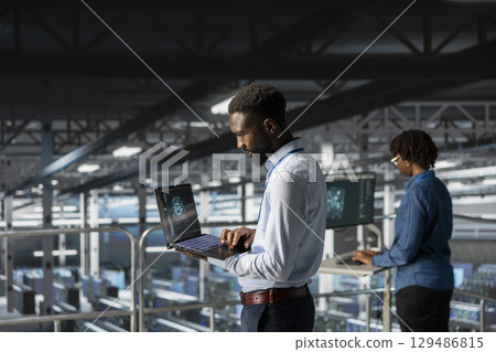 IT experts on data center industrial platform pleased by neural network outputs after completing AI software updates. System administrators team finetuning server rig configurations. IT experts on data center industrial platform pleased by neural network outputs after completing AI software updates. System administrators team finetuning server rig configurations. 129486815