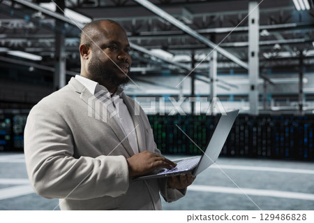 Engineer in server farm auditing systems for vulnerabilities, checking recovery plan. Data center IT specialist troubleshooting connectivity issues, making sure rigs are functioning optimally Engineer in server farm auditing systems for vulnerabilities, checking recovery plan. Data center IT specialist troubleshooting connectivity issues, making sure rigs are functioning optimally 129486828