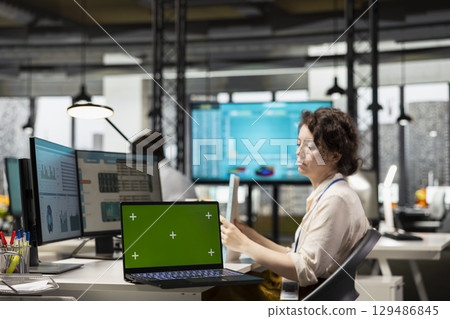 Professional manager reviewing charts reports next to isolated chroma key, applying a new growth strategy and vision to drive innovation and improve overall company performance. Efficiency. 129486845