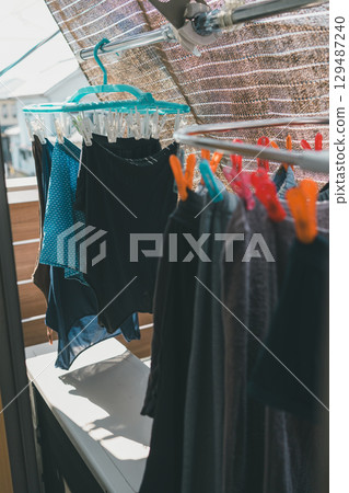 A family drying laundry in a small space inside a sunshade 129487240