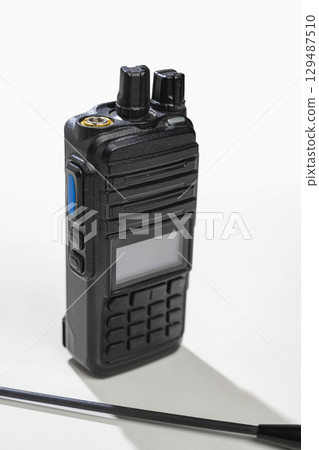Closeup view of a black walkie talkie radio communication device isolated over a white background Closeup view of a black walkie talkie radio communication device isolated over a white background 129487510