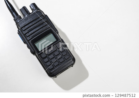 Closeup view of a black walkie talkie radio communication device isolated over a white background Closeup view of a black walkie talkie radio communication device isolated over a white background 129487512