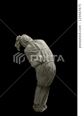 Pocongs on a black background. A traditional ghost from Indonesia that takes the form of a human wrapped in a shroud or winding sheet. Concept of Halloween 129487675