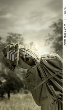 Pocong on the field at night. A traditional ghost from Indonesia that takes the form of a human wrapped in a shroud or winding sheet. Concept of Halloween Pocong on the field at night. A traditional ghost from Indonesia that takes the form of a human wrapped in a shroud or winding sheet. Concept of Halloween 129487690