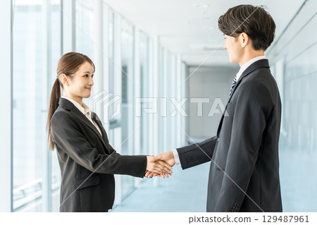 商人和女士在公司辦公室握手問候、自我介紹並簽訂合同 129487961