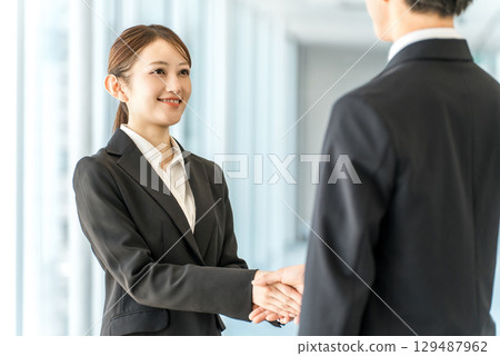 商人和女士在公司辦公室握手問候、自我介紹並簽訂合同 129487962