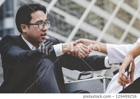 Arab Businessman shaking hands together. Teamwork business partner wear Muslim dress Shake Hands with Partnership Concept. Success UAE diversity people trust make commitment by handshake 129489256