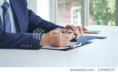 Businessman hand using pen signing on new contract starting projects in conference room. Close up business manager man hands sign contract legal document in meeting room. Business agreement concept Businessman hand using pen signing on new contract starting projects in conference room. Close up business manager man hands sign contract legal document in meeting room. Business agreement concept 129489257