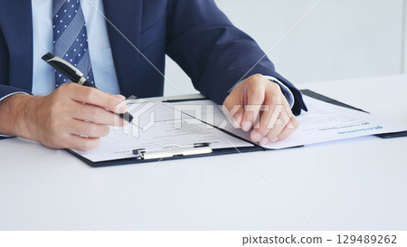 Businessman hands note meeting document in conference room. man Hands writing planning notebook. Close up male hand holding pencil write on diary sketchbook at office desk. Business Planning Concept Businessman hands note meeting document in conference room. man Hands writing planning notebook. Close up male hand holding pencil write on diary sketchbook at office desk. Business Planning Concept 129489262