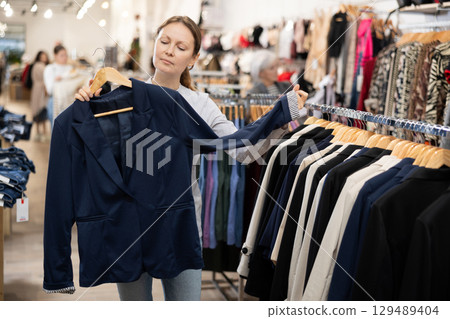 Adult woman choosing blazer in store Adult woman choosing blazer in store 129489404