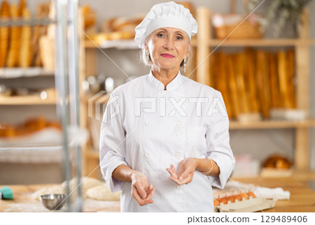 Portrait of professional mature female baker in white uniform in bakery Portrait of professional mature female baker in white uniform in bakery 129489406