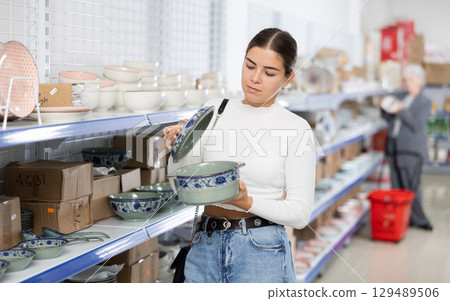 Young female shopper choosing porcelain soup tureen at Asian store 129489506