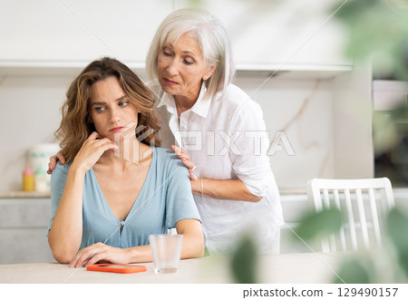 Elderly woman quarrels with couple in kitchen 129490157