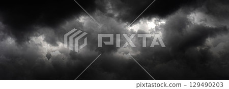Banner Dramatic dark storm clouds black sky background. Dark thunderstorm clouds rainny season. Panorama Meteorology danger windstorm disasters climate. Dark cloudscape storm cloud with copy space. Banner Dramatic dark storm clouds black sky background. Dark thunderstorm clouds rainny season. Panorama Meteorology danger windstorm disasters climate. Dark cloudscape storm cloud with copy space. 129490203