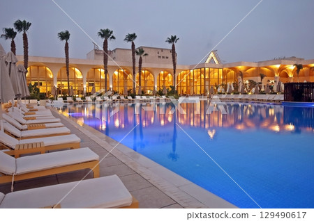 泳池邊擺放著一排躺椅 129490617