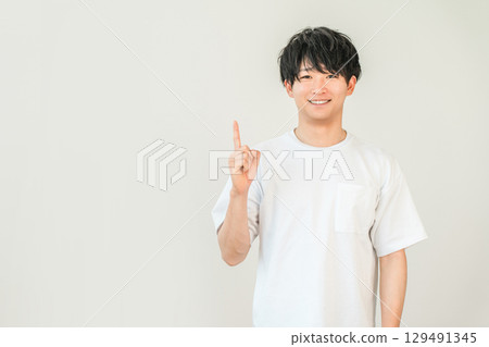 A young Asian man in a T-shirt pointing (point, introduction, guide, recommendation, guidance) 129491345