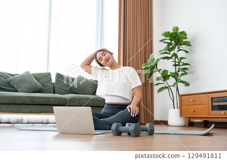 Young Asian woman stretching yoga workout on exercise mat 129491811