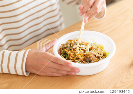 一名國中女孩在房間裡吃杯麵 一名國中女孩在房間裡吃杯麵 129493445