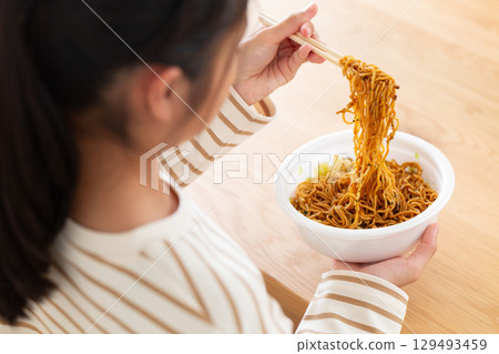 一名國中女孩在房間裡吃杯麵 129493459
