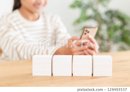 一名國中生正在家中使用智慧型手機,旁邊是一塊白色積木 一名國中生正在家中使用智慧型手機,旁邊是一塊白色積木 129493537