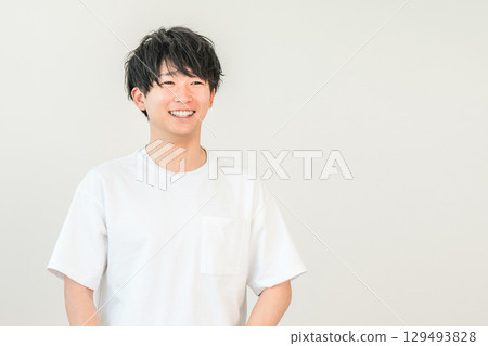 Smiling Asian man in an oversized t-shirt Smiling Asian man in an oversized t-shirt 129493828