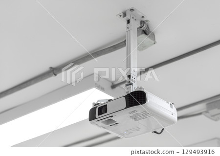 A white overhead projector on ceiling indoors. 129493916