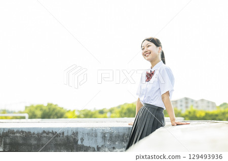 High school girls relaxing on the school rooftop 129493936