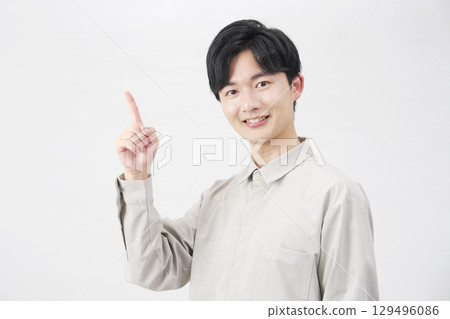 20 多歲的男子指著左邊，白色背景 129496086