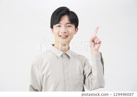 20 多歲的男子指著右邊，白色背景 129496087