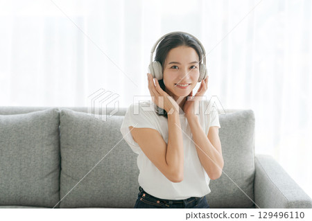 婦女在客廳裡聽音樂 129496110