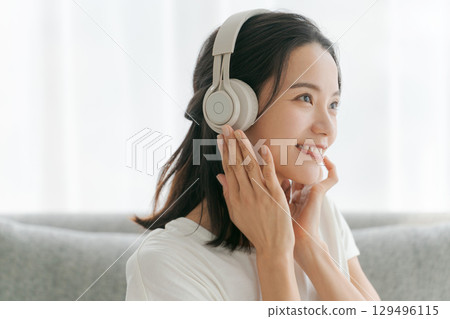 Women listening to music in the living room Women listening to music in the living room 129496115