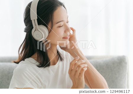 婦女在客廳裡聽音樂 129496117